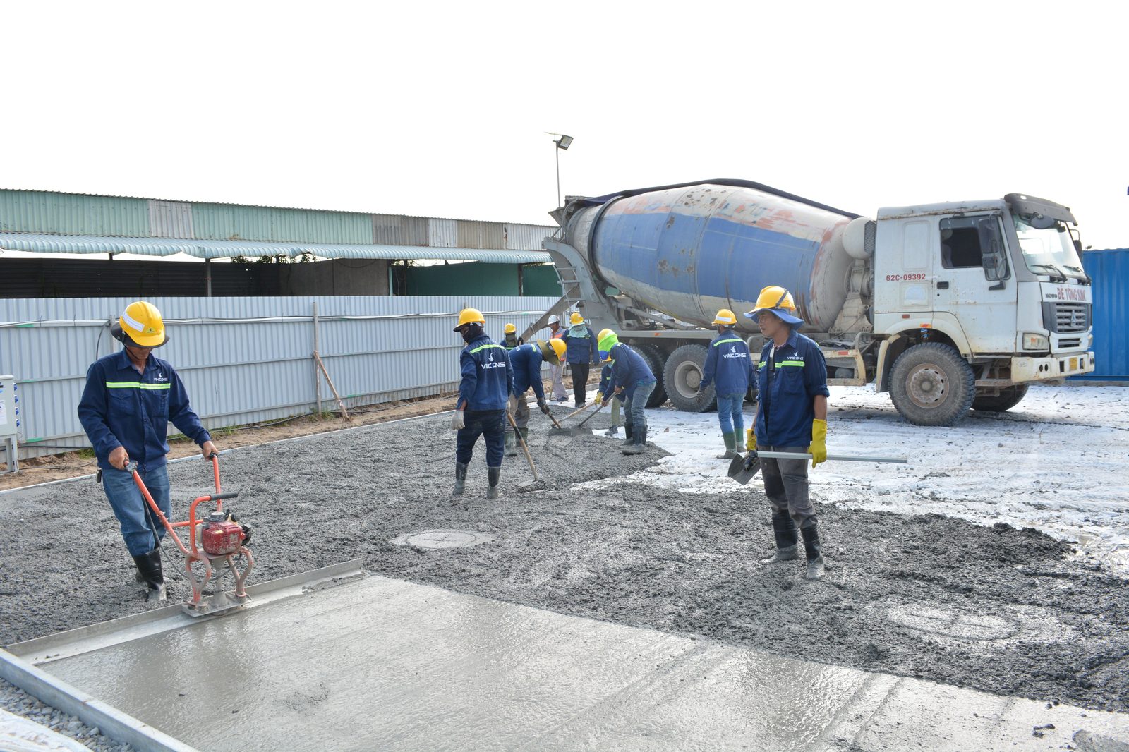 Construction crew pouring concrete with a mixer truck